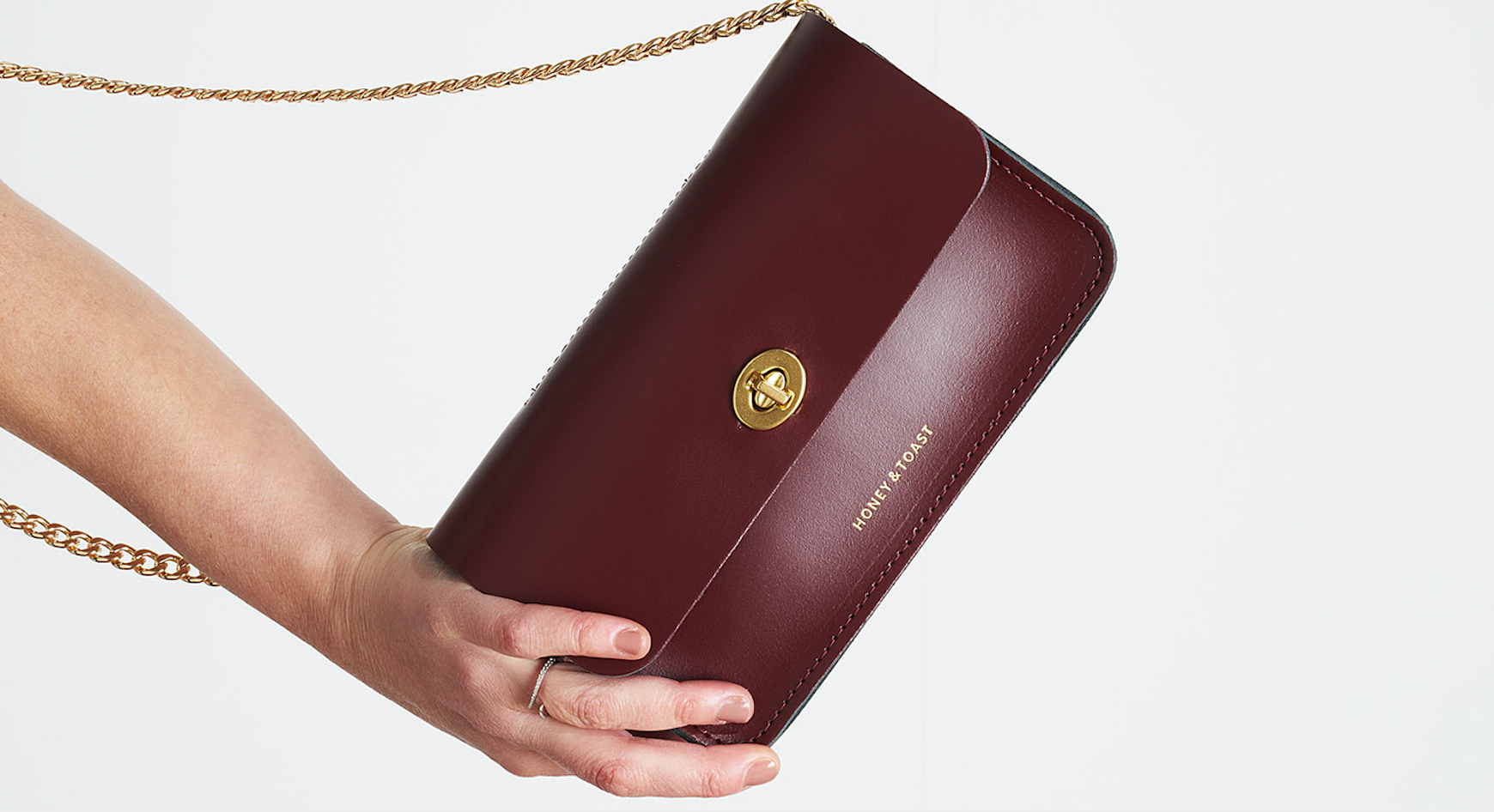 Honey and Toast leather clutch bag in damson leather with turnlock