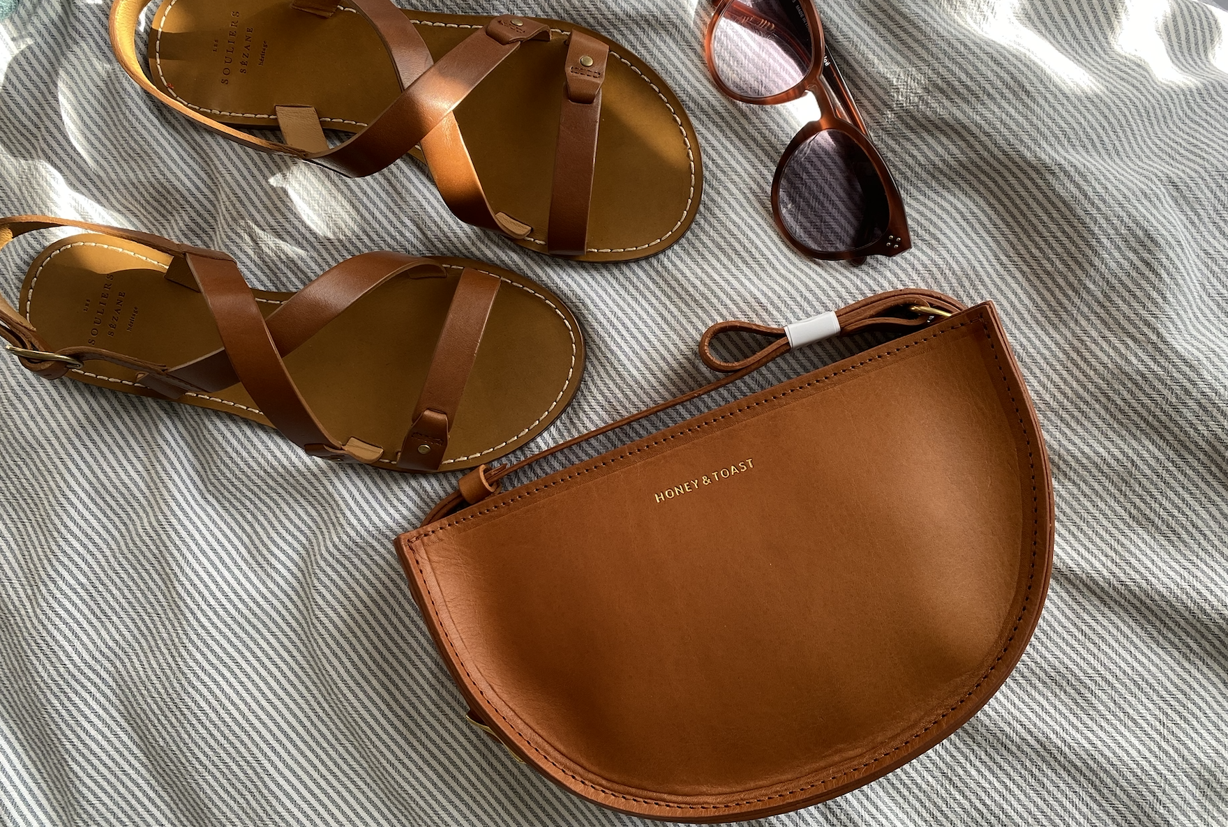 Honey and Toast leather half moon bag with summer sandals and sunglasses