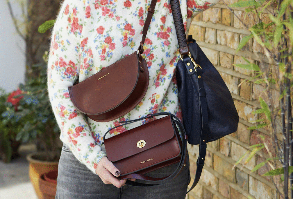 Woman wearing 3 different Honey and Toast bags, a dark red clutch, half moon and slouchy leather shoulder bag
