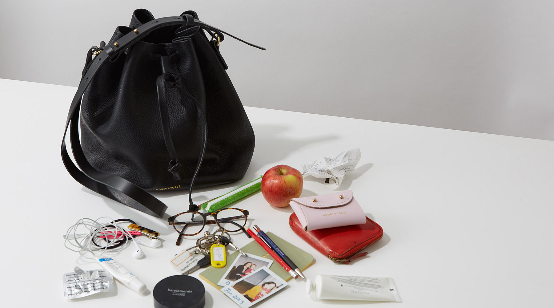 Honey and Toast black leather Anna bucket bag with contents of the bag